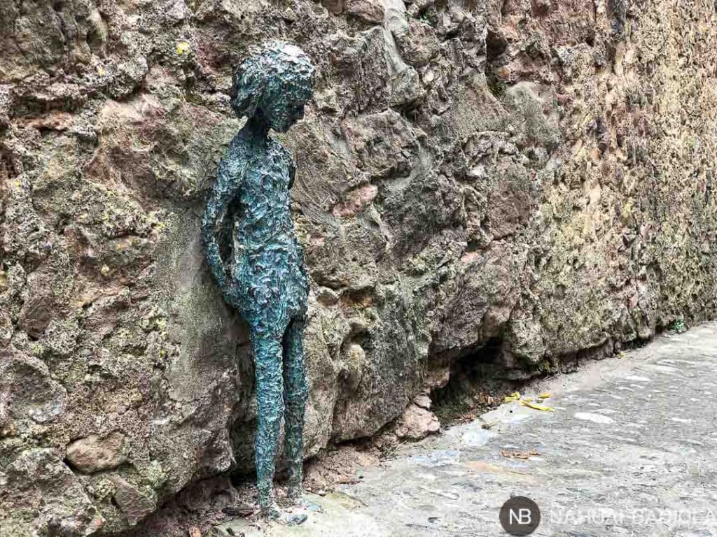 Pequeña escultura de metal con forma de niña en Santa Pau